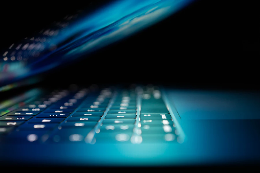 Laptop keyboard glowing blue in a dark room